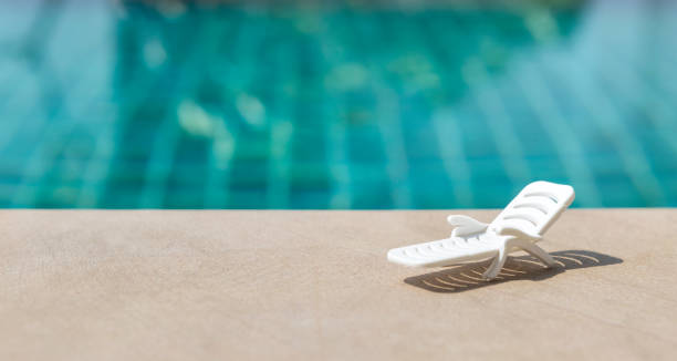 istock White beach chair over swimming pool background 680384682