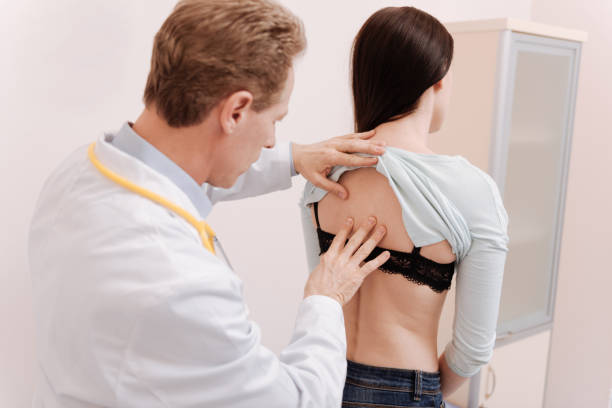 istock Gentle careful doctor checking young womans back 680386432