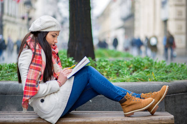 istock Student girl relaxing and reading book outdoors. 680386448