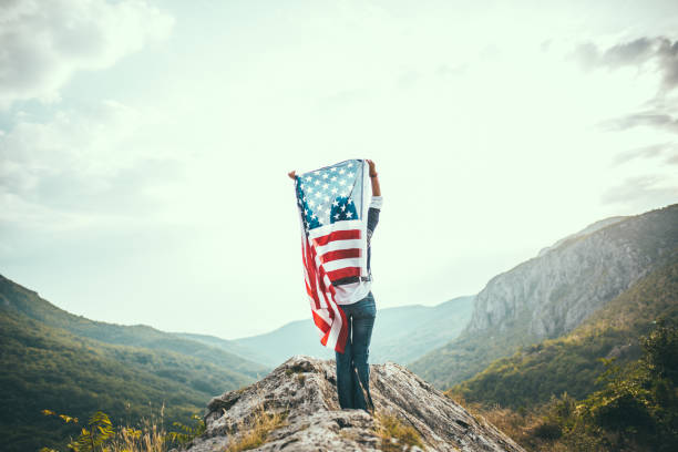 istock Woman with US flag on mountain 680387346