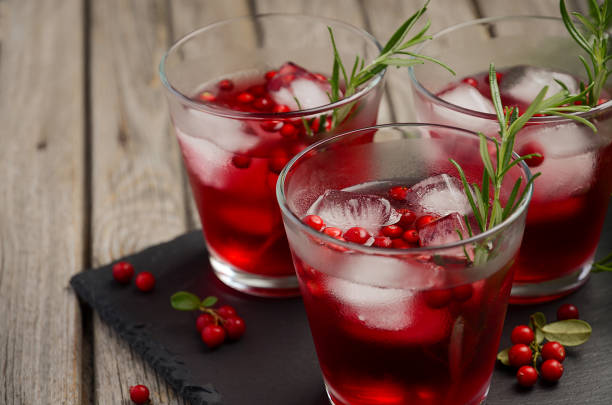 istock Refreshing drink with cranberries and rosemary on wooden background 680392842