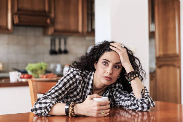 istock Young woman sitting alone at home 680393310