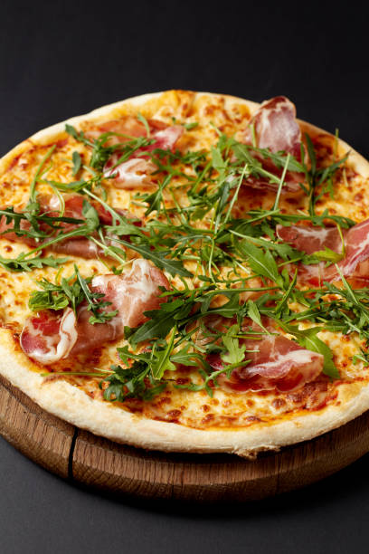 istock Hot pizza Prosciutto on a rustic wooden table. 680399402