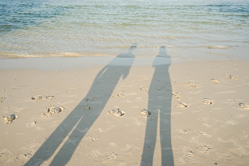shadow of couple on the sand at seaside