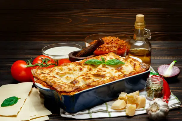 Lasagna in baking dish isolated on wooden background