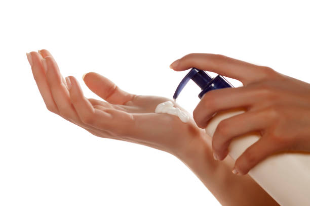 istock Woman applying cream on her arm from the pump 680409160