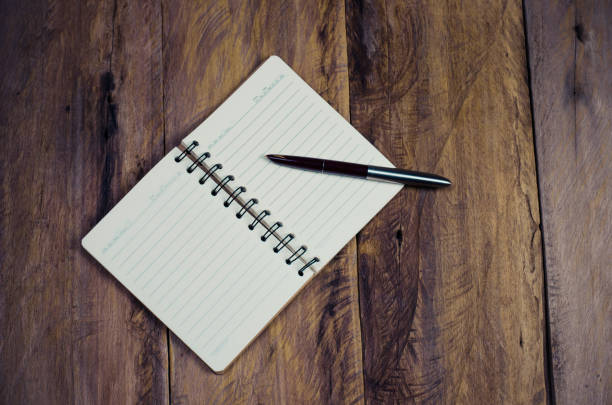 istock blank notebook with pen on wooden table - still life 680409676