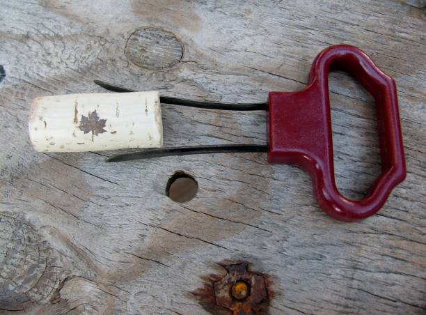 Two prong cork puller and  wine cork Two prong cork puller and  wine cork on a wooden background cork puller stock pictures, royalty-free photos & images