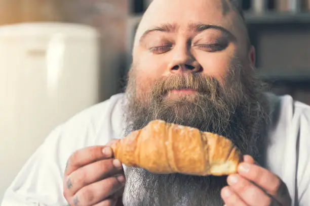 Photo of Starving fat guy enjoying smell of pastry