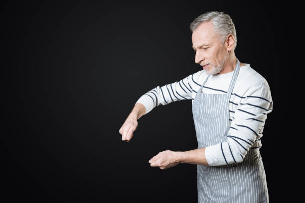 homme sérieux en imaginant cette exploitation des instruments de cuisine - looking at camera facial expression gesturing touching photos et images de collection