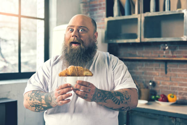 istock Excited thick guy having breakfast at home 680412240