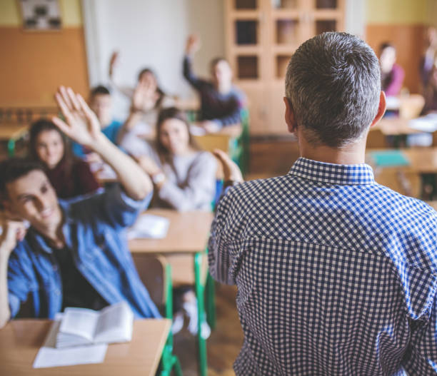 istock Back view of professor teaching in the classroom. 680424198