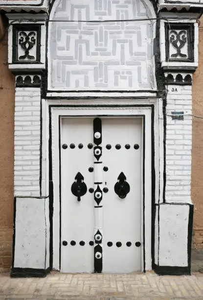Beautiful decorated old Persian white door with black detail in Yazd, Iran