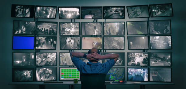Big brother watching you Giant surveillance desk with monitors and someone watching monitors big brother orwellian concept stock pictures, royalty-free photos & images