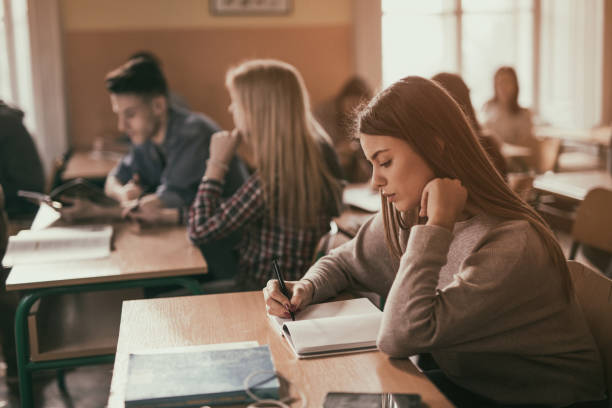 istock Female high school student taking notes in the classroom. 680425242