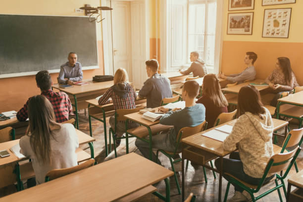 istock Group of high school students listening to their teacher on class. 680430802