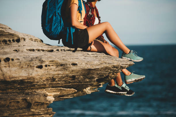 Girls sitting on the edge of the cliff.