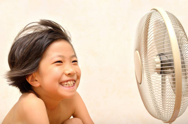 istock Girl cools off with a fan 680431358