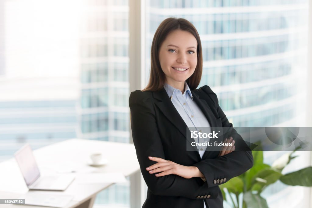 Jeune femme d'affaires confiante de sourire restant dans le bureau avec des bras croisés - Photo de Avocat - Juriste libre de droits