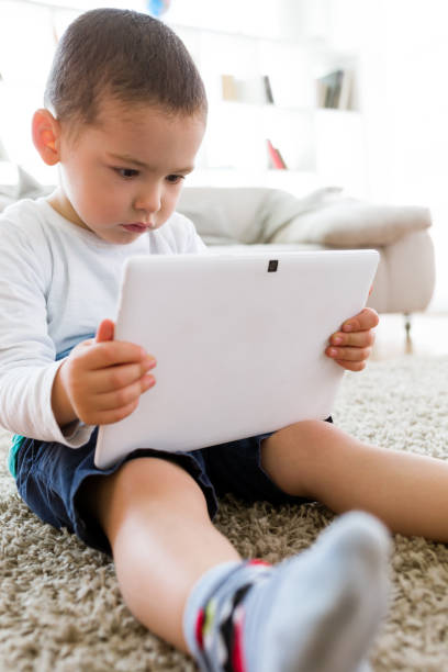 istock Beautiful young boy using his digital tablet at home. 680437588