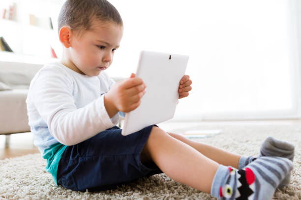 istock Beautiful young boy using his digital tablet at home. 680439896