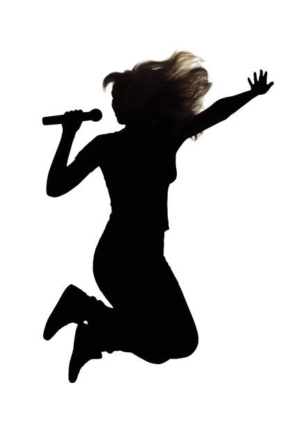 silueta de mujer saltando con un micrófono - talent show audio fotografías e imágenes de stock
