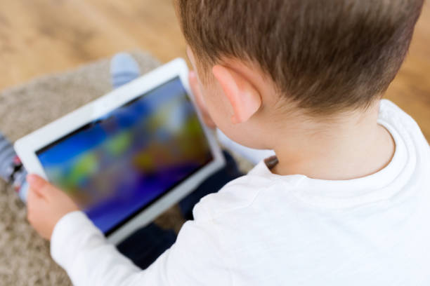 istock Beautiful young boy using his digital tablet at home. 680441560