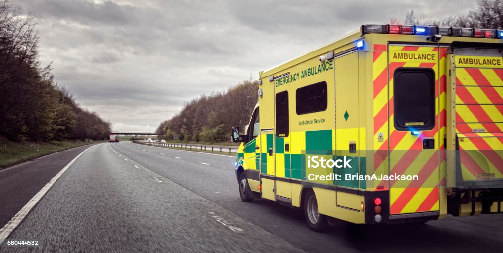 Ambulance British ambulance responding to an emergency in hazardous bad weather driving conditions on a UK motorway Ambulance Stock Photo