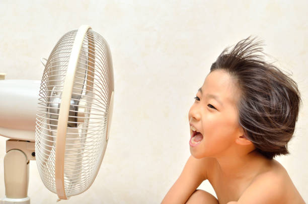 istock Girl cools off with a fan 680444970
