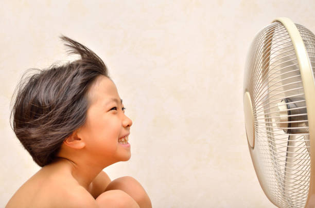 istock Girl cools off with a fan 680446762