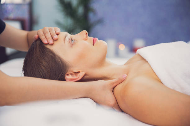 istock Young woman enjoying face and collar area massage 680447202