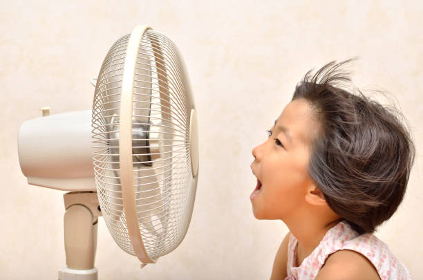 istock Girl cools off with a fan 680447944