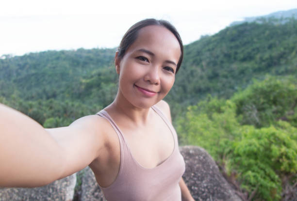 istock Asian woman taking selfie from mountain viewpoint. 680449946