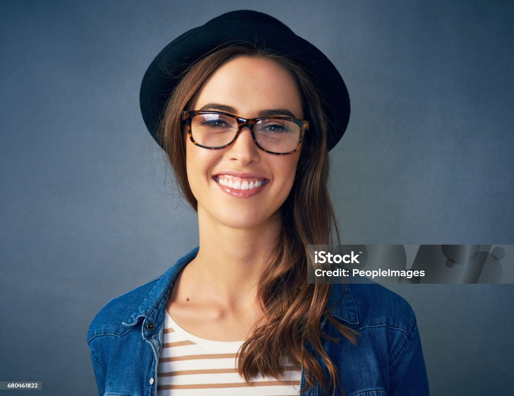I think of myself as a limited edition Portrait of a quirky young woman smiling against a gray background in studio 20-29 Years Stock Photo