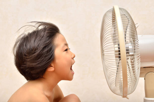 istock Girl cools off with a fan 680465326