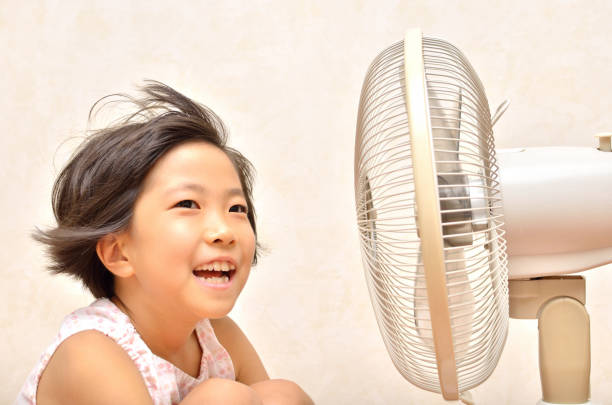 istock Girl cools off with a fan 680465950