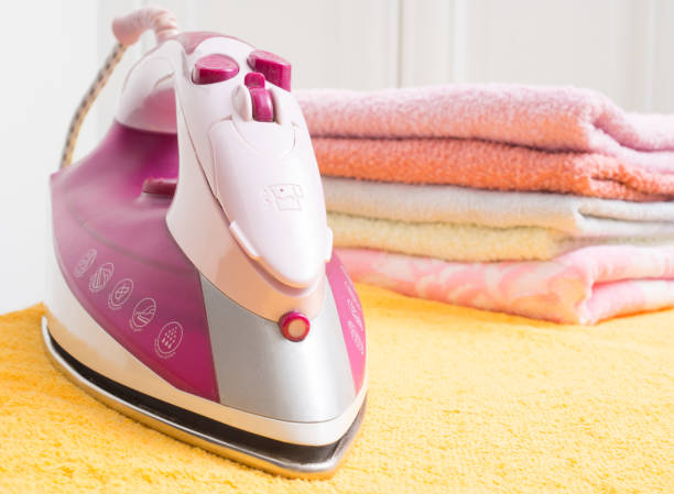 istock Ironing board with colorful towels on white background 680479192