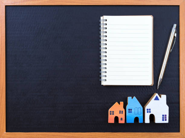 istock Blank notebook and wooden miniature house 680486210