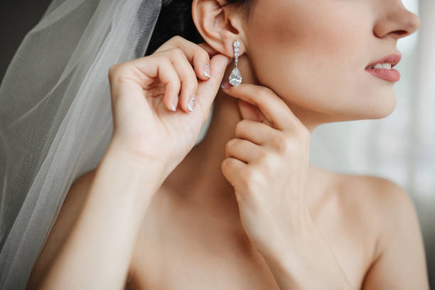 Wedding preparation. Beautiful, happy bride dresses earrings before wedding. Wedding accessories, jewelry. Closeup portrait of bride. Selective focus. Wedding preparation. Beautiful, happy bride dresses earrings before wedding. Wedding accessories, jewelry. Closeup portrait of bride. Selective focus. hairstyle bride jewelry women stock pictures, royalty-free photos & images