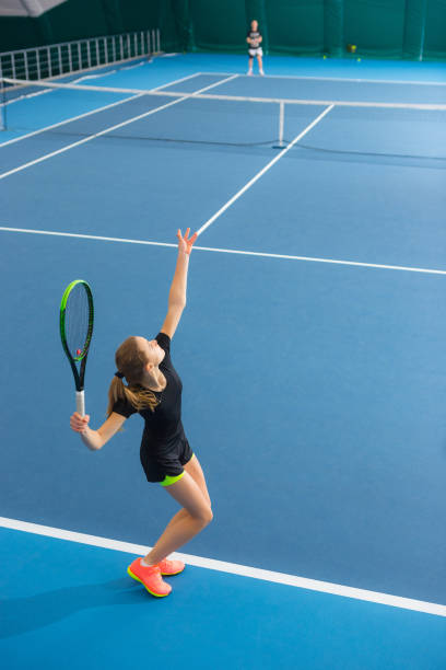 ボールと閉じたテニスコートで若い女の子 - tennis indoors women court ストックフォトと画像