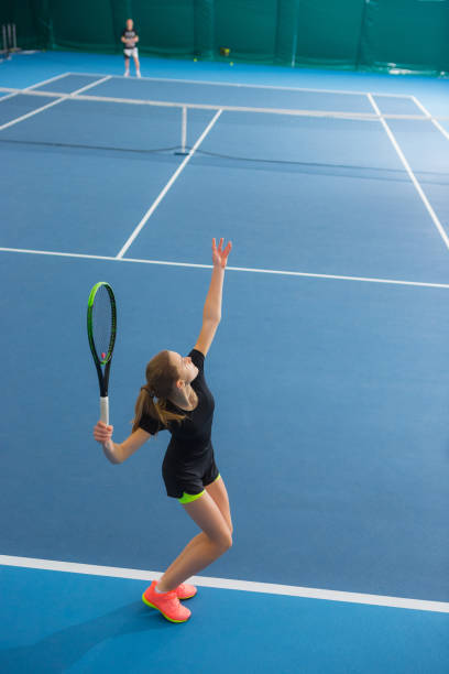 ボールと閉じたテニスコートで若い女の子 - tennis indoors women court ストックフォトと画像