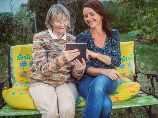 istock Two women using a tablet in the garden 680497130