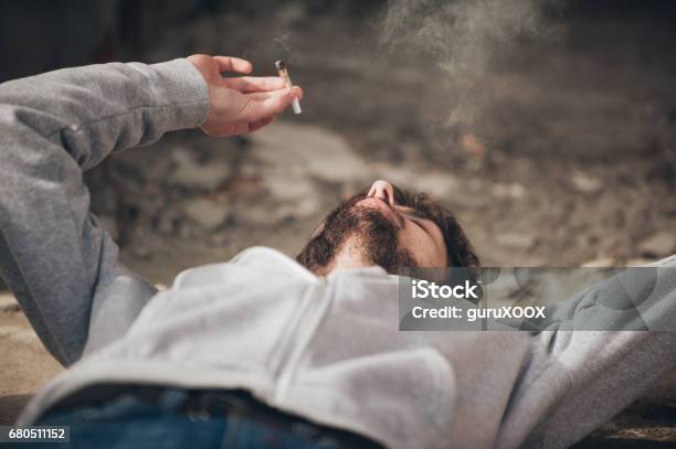 Closeup Of Man Lying On The Ground And Smoke Joint Stock Photo - Download Image Now - Cannabis - Narcotic, Fun, Marijuana - Herbal Cannabis