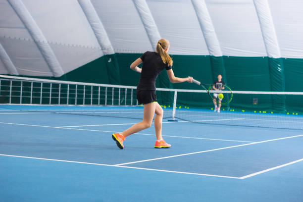 ボールと閉じたテニスコートで若い女の子 - tennis indoors women court ストックフォトと画像