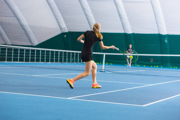 a menina na quadra de tênis fechada com bola - tennis court indoors net - fotografias e filmes do acervo