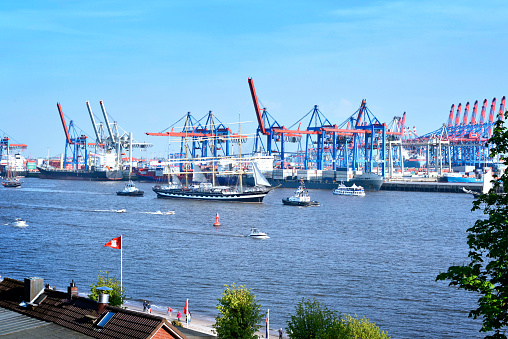 Hamburg harbor, birthday parade with various ships. View to Hamburg harbor with harbor cranes.