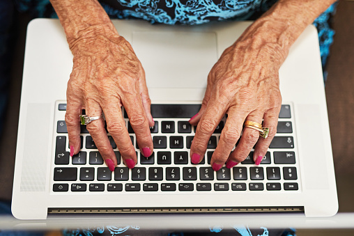 Cropped shot of a senior woman typing on a laptop keyboard