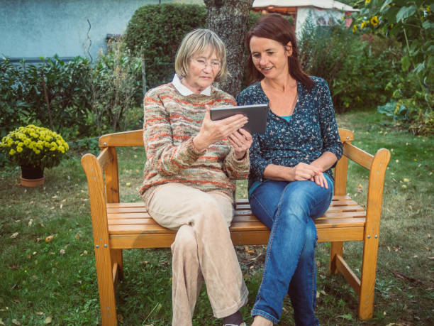 istock Two women using a tablet in the garden 680513092