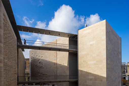 Government worker walks across a link walkway in the Parliament Building in Valletta, Malta.