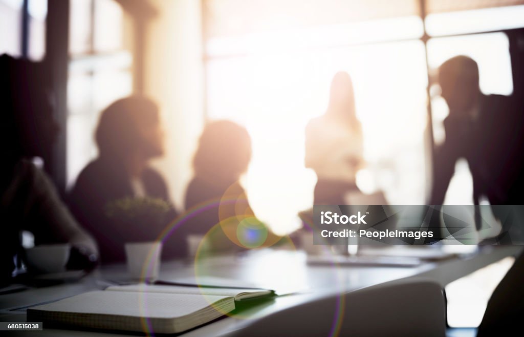 Conceptualizing boardroom business Shot of a group of business colleagues talking together during a meeting in a boardroom Obscured Face Stock Photo